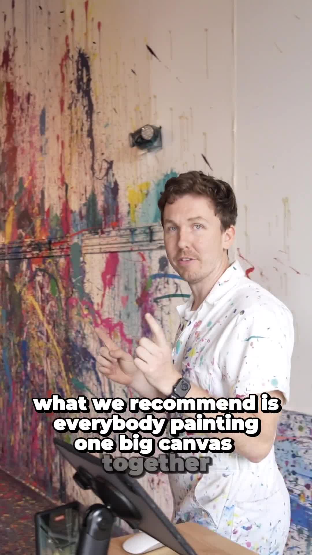 Tim Edwards in the studio, paint-covered wall behind him.
