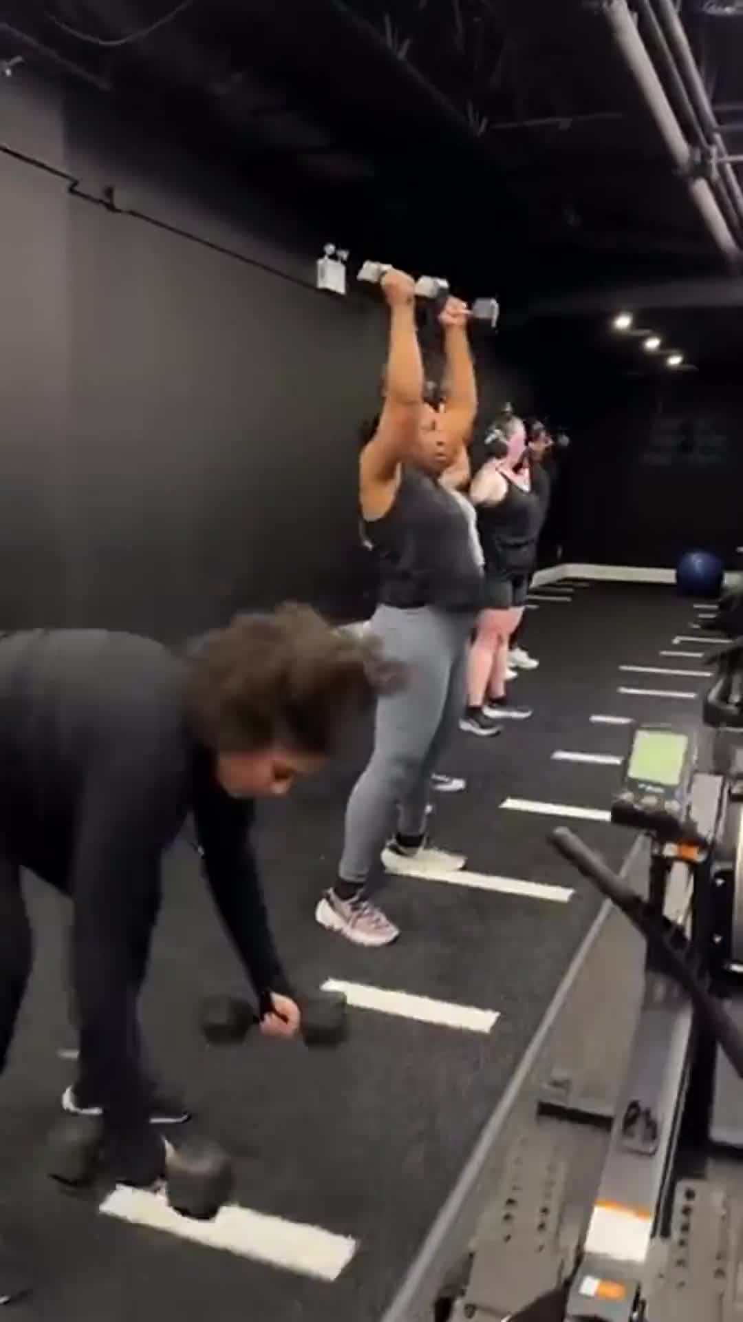 Members lifting dumbbells during mixed Power House group training