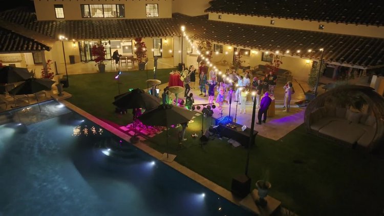 Crowd in front of a lit stage at a desert event at night