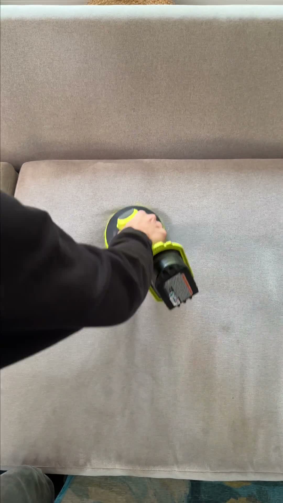 Steam cleaning a light gray couch in a Bay Area home