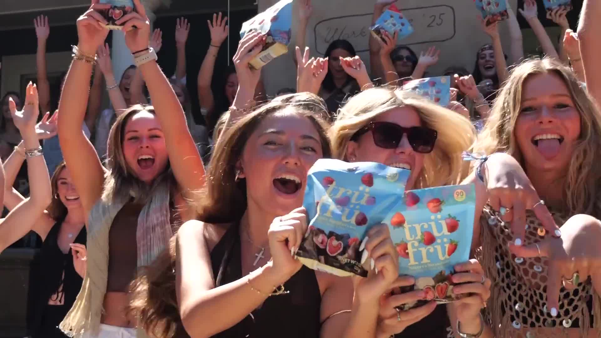 Excited crowd holding up Tru Fru bags at a Front & Center sampling event