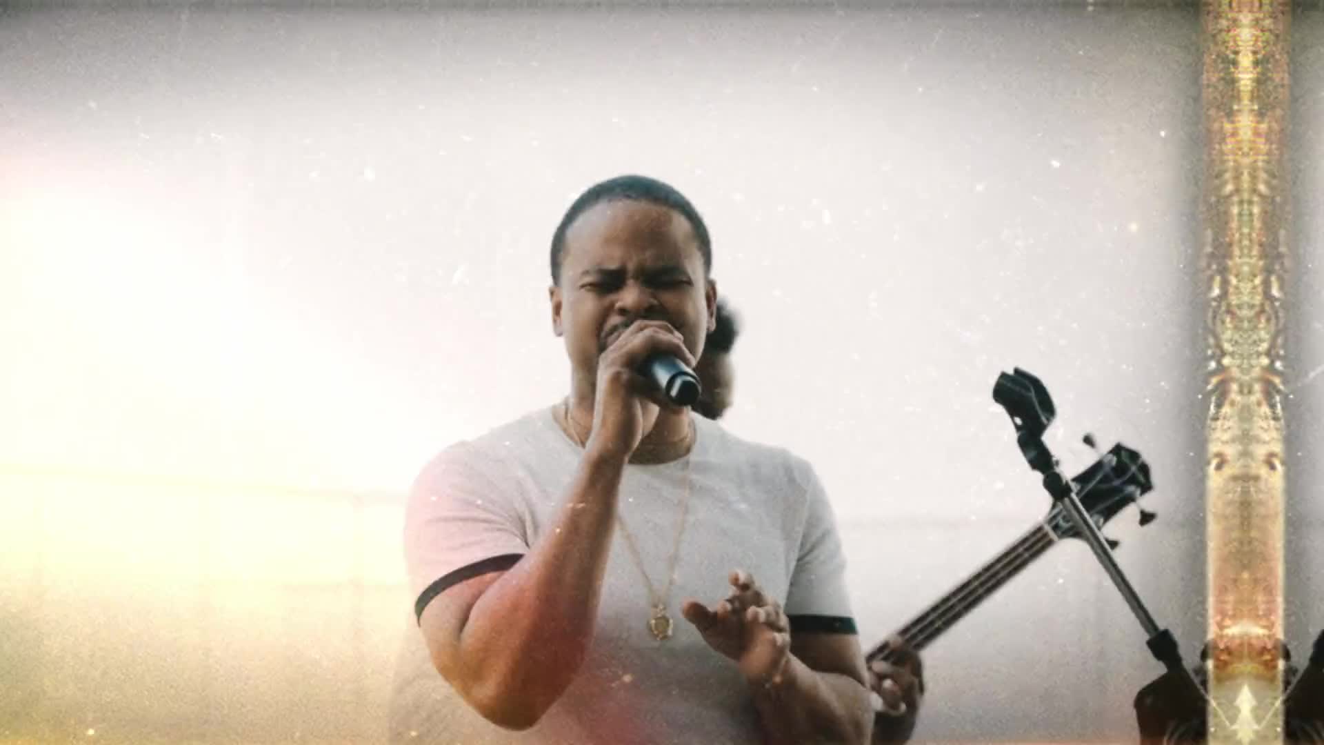 Kenny Sharp singing into a microphone with his band